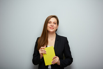 Fototapeta premium Woman teacher holding yellow book. Isolated portrait with copy space.