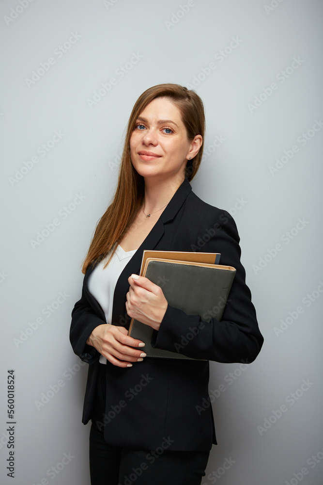 Poster Young school teacher woman holding books or workbooks. Business woman in black suit.