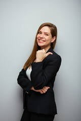 Smiling woman in black suit pointing thumb at side. Isolated portrait female business person.