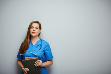 Serious doctor woman or nurse in blue medical suit with book. Isolated portrait of female medical worker.