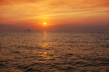 Beautiful sunset landscape with dramatic sky, sun and sea water