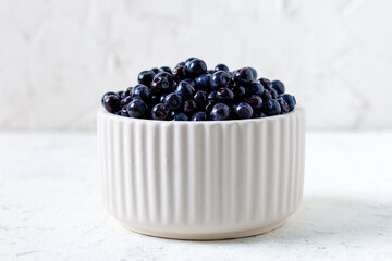 Fresh blueberries in white ceramic bowl on table.