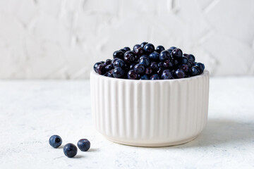Fresh blueberries in white ceramic bowl on table.