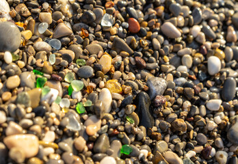 Colored Sea Glasses on Pebble Beach Texture Background, Multicolored Rocky Shore with Copy Space