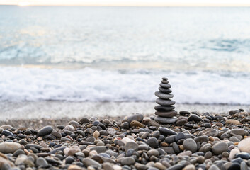 Stone pyramid. Pebbles balance pile, harmony zen stones, balance stack, sea pebble pyramid on shoreline, relaxation