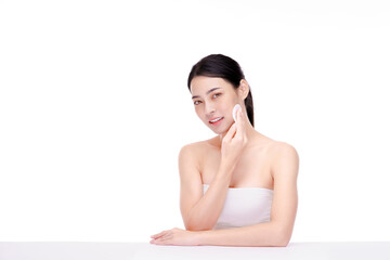 Attractive beauty young asian woman clean skin with cotton pad removing make up on white background. © edkoumi