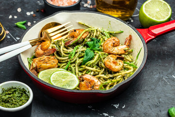 zucchini spaghetti with shrimp in pan. Food recipe background. Close up
