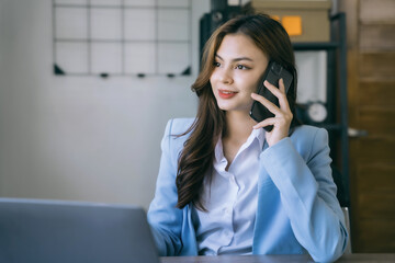 Fototapeta premium Asian business woman using mobile phone in office.