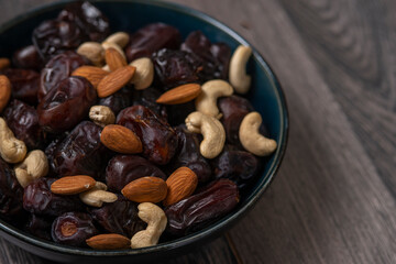 dates and nuts in a bowl on a dark background