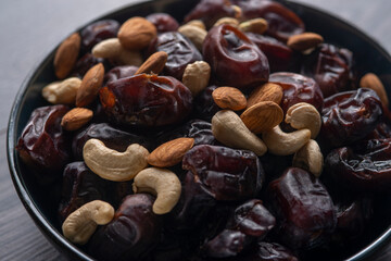 dates and nuts in a bowl on a dark background