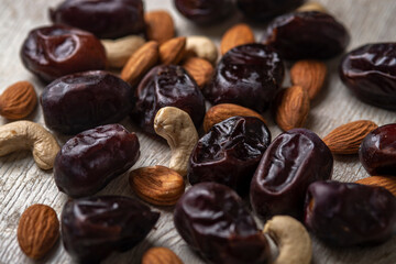 dates and nuts in on a serum wooden background