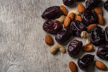 dates and nuts in on a serum wooden background