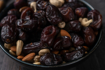 dates and nuts in a bowl on a dark background