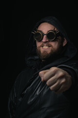 Fototapeta premium A man in a hood, wearing vintage steampunk goggles looking at the camera close-up