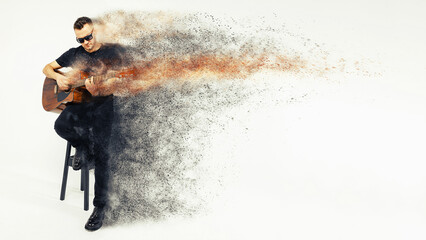 a man with a guitar, an artist, a guitarist, a singer sits on a chair on a gray background, with the effect of scattering into particles