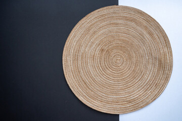 Empty straw table mat on black and white background table. Flat lay, top view, copy space. Food...