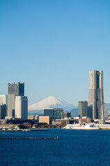 クルーズ船越しに見る横浜港越しの富士山とランドマークタワー