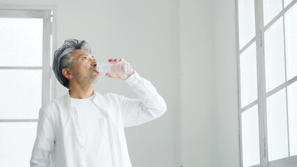 ペットボトルの水を飲むシニア男性