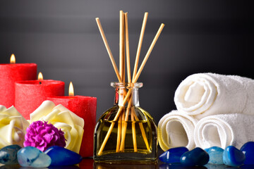 Reed diffuser with candle and towel on table - obrazy, fototapety, plakaty