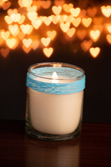 Candle blowing against heart shape bokeh background