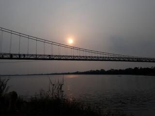 Sunset with Suspension bridge on a river