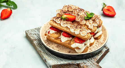 Strawberry tiramisu with mascarpone and mint. Traditional italian dessert tiramisu with strawberry on light background. Long banner format