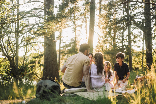 Happy family spending leisure time during picnic in forest