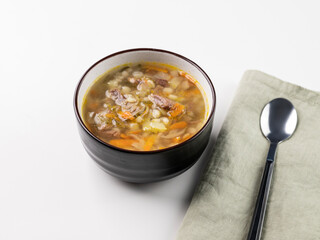 Traditional Russian soup with pickled cucumbers. Pickle with pearl barley and meat on a white background