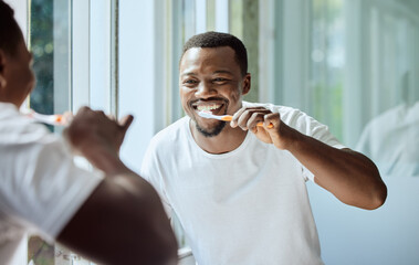 Morning, happy and black man brushing teeth in bathroom for health, hygiene and clean smile. Self...