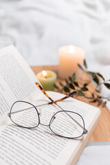 book with plant and candles and glasses