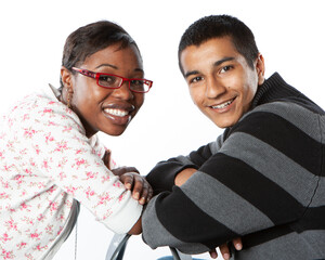 Teenage Students: Friendly Faces, Bright smiles from a couple of diverse, late-teenage friends looking over to the camera. From a series of images.