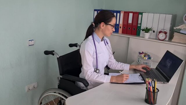 Doctor therapist cardiologist disabled in wheelchair works in clinic. Disabled doctor and medical services