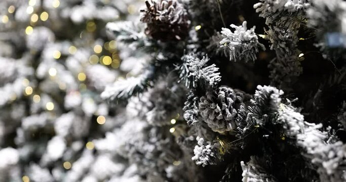 Closeup of Christmas tree with lights and snow flakes