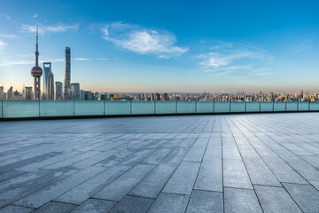 Empty square floor and city skyline with modern buildings at sunrise in Shanghai, China.