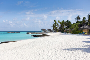 Beach of a tropical island with white sand and turquoise water on the maledives