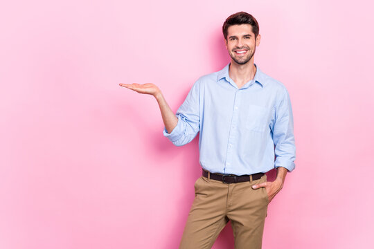 Photo of joyful cheerful man arm demonstrate empty space cool proposition vacancy isolated on pink color background