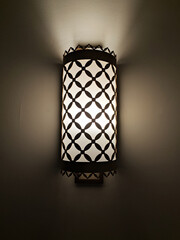 switched on vintage sconce on a dark wall