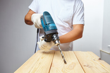 man holding a cordless screwdriver in his hand.