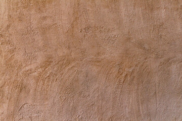 Old traditional house wall texture in Shindaga, Dubai. Dark brown sandy color rough plaster background.
