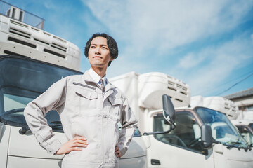 トラックの前に立つ若い男性ドライバー