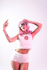 Young woman with pink hair dancing and having fun. Colored gel portraits with futuristic outfit