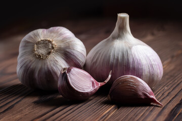Garlic cloves on wooden table. Fresh peeled garlics and bulbs.
