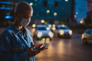 Image of a young woman using mobile phone on the street.
