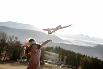Mädchen spielt mit Modellgleitflugzeug
