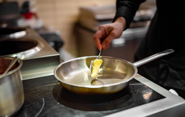 chef frying butter in pan at kitchen