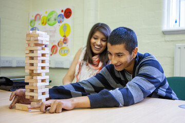 Gaming Teenagers: Tension. A tense moment during a popular wooden block game being played by late teenage friends. From a series of related images.