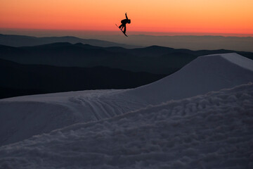 Snowboarder Spencer O'Brien jumping at sunset at Mt. Hood