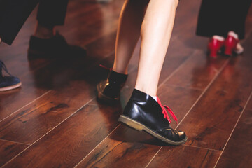 Dancing shoes of young couple dance retro jazz swing dances on a ballroom club wooden floor, close...
