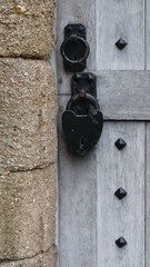 Old Metal Black Heart Shaped Lock on wooden door on stone building
