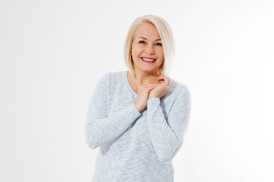 Happy beautiful close up portrait middle age blonde woman. Mid aged healthy female isolated on white background with copy space. Menopause and healthcare. Mature lady wrinkled face. Folded hands